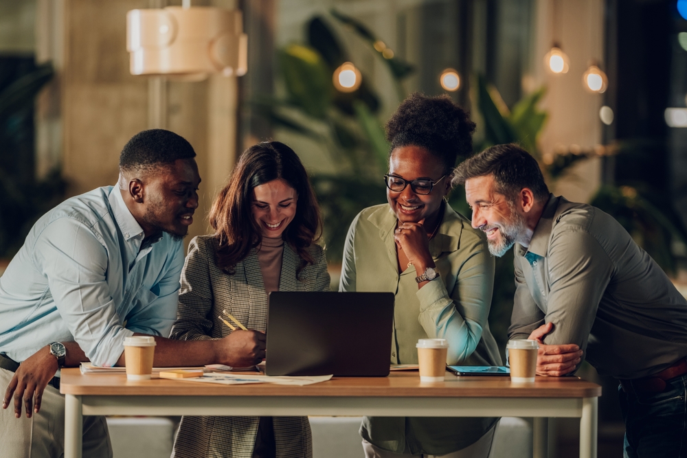 Four,Happy,Diverse,Business,Professionals,Discussing,Project,And,Working,Together